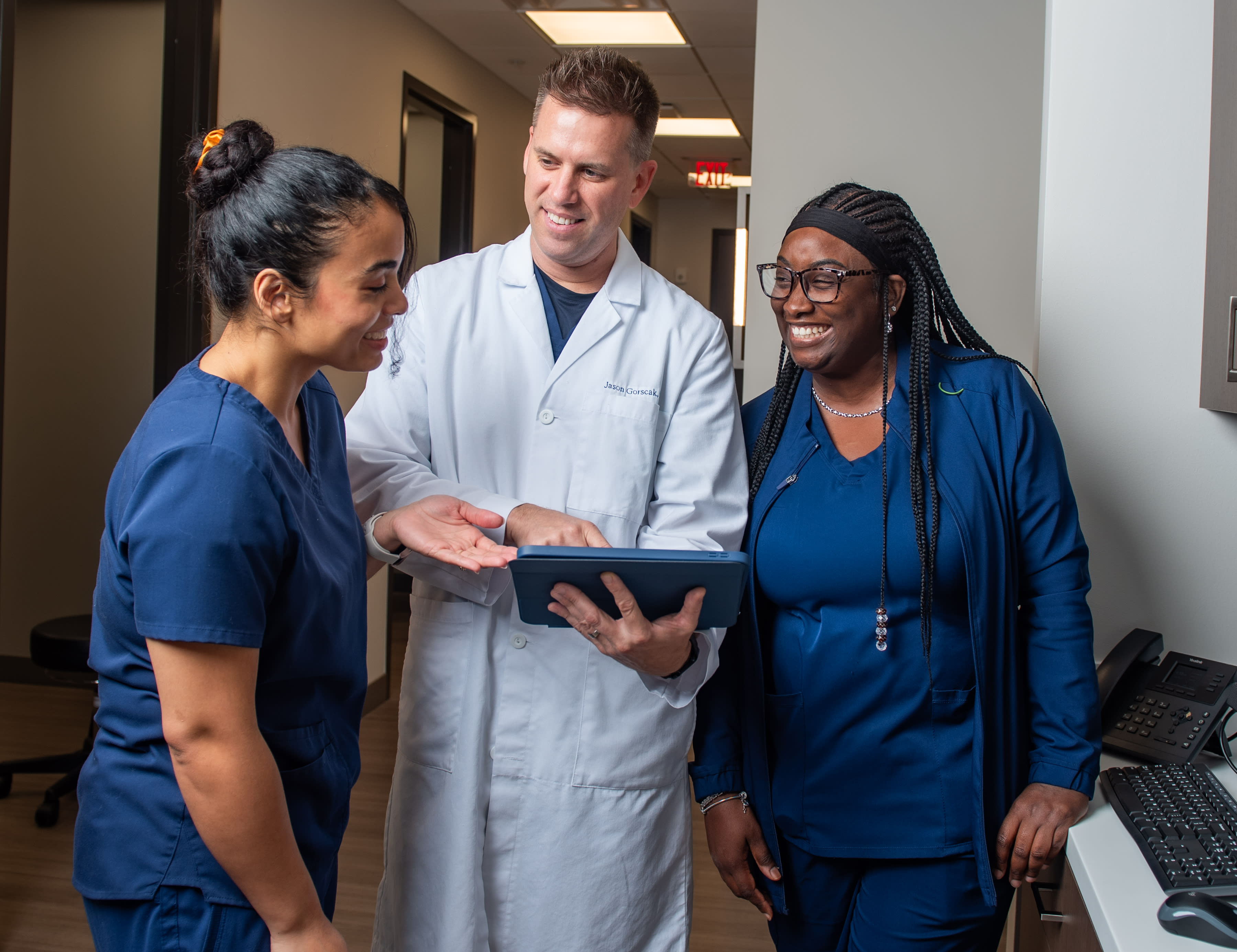 Dr. Jason Gorscak reviews patient care details with technicians Rachel Maldonado (left) and Tavia Anderson (right), ensuring seamless coordination and a personalized approach to every visit.