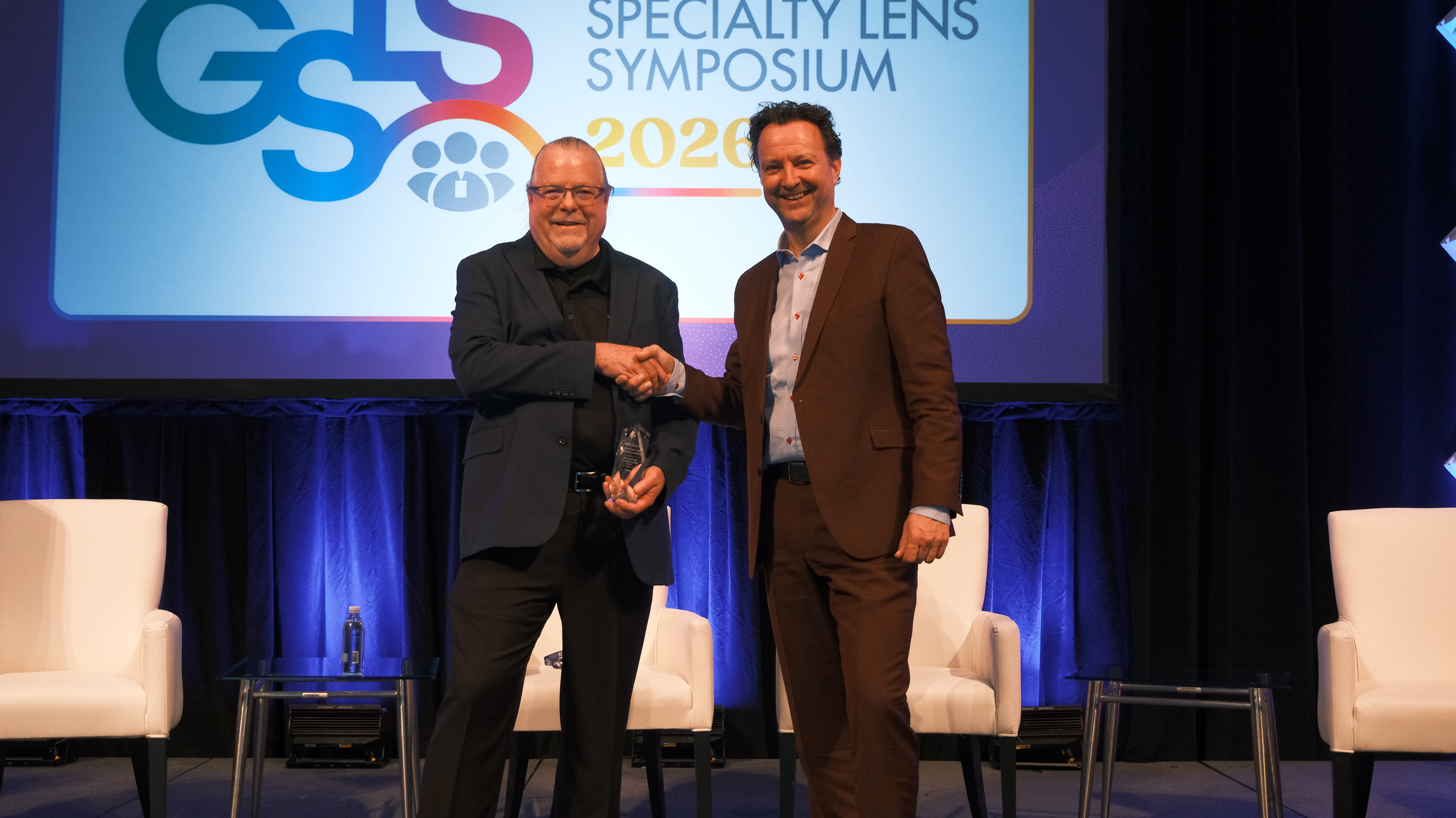 Eef van der Worp, BOptom, PhD, presents the GSLS Award of Excellence to Patrick J. Caroline.