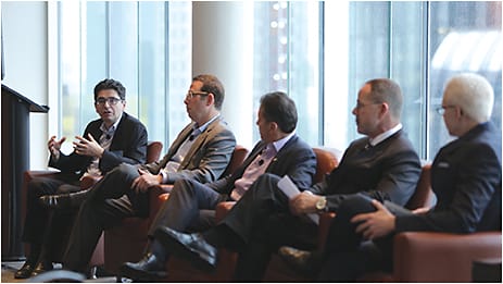 Essilor of America president Eric Leonard (left) makes a point about the Luxottica merger at the Essilor press breakfast