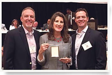 Wiley X co-owners Myles Freeman Jr. (left) and Dan Freeman flank California Assemblywoman Catherine Baker at their award ceremony