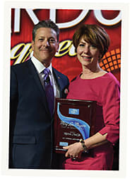 Fran Lynch is awarded the Mary Lou Maguire Award by Essilor's Howard Purcell, O.D., during the awards banquet