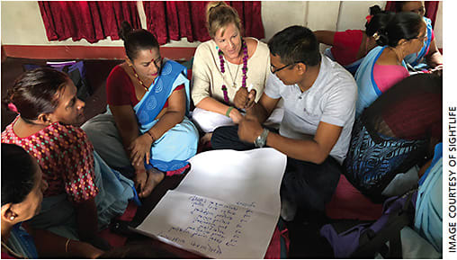 Prevention program supervisor Ajay Chaudhary (center right) leads a refresher training session with Nepalese community health workers. To his right sits SightLife Advocate Abigail Markward.