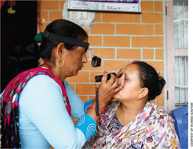 A Nepalese community health worker trained by SightLife conducts an eye exam on a patient.