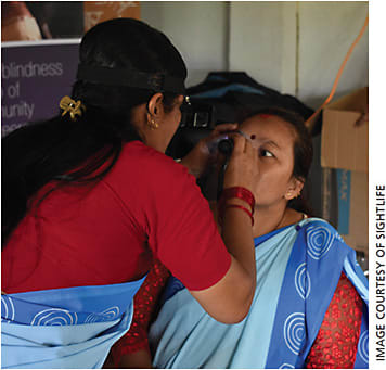 A community health worker demonstrates a perfectly executed eye exam during refresher training.