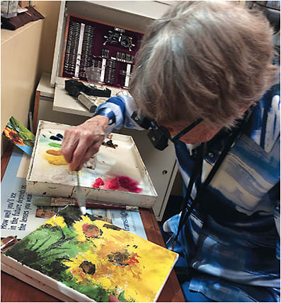 A low vision patient paints with device assistance.