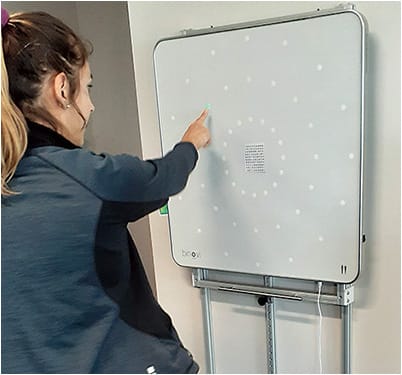 A patient performs peripheral awareness training using a saccadic fixator.Photo courtesy of Dr. Patrick T. Quaid.