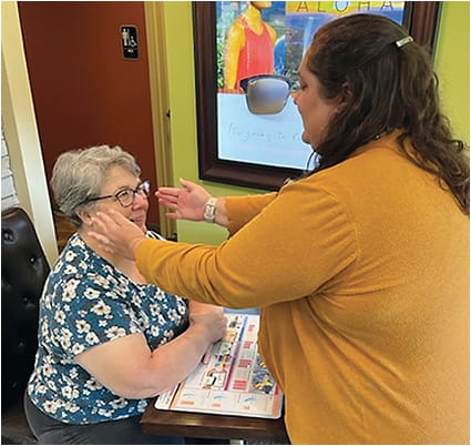 Two members of Dr. Earley’s staff demonstrate dispensing of progressive addition lens for a presbyopic patient. Photo courtesy of Dr. Timothy Earley.