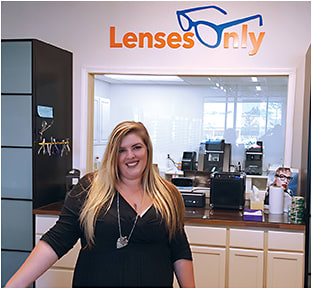 Apprentice optician Danielle Leone at the reception counter of Lenses Only, which features a window into the lab