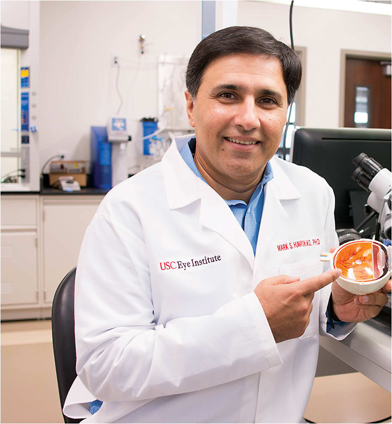 Mark Humayun, M.D., Ph.D, co-inventor of the Argus Series retinal implant, holds a model of an eye.
Photo courtesy of USC Roski Eye Institute