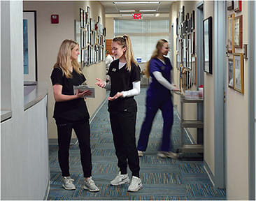 From left: Rachel Peyton, OD intern, UMSL, in discussion with Sarah Bowen, technician, with Rylie Sell, technician (in the background).
