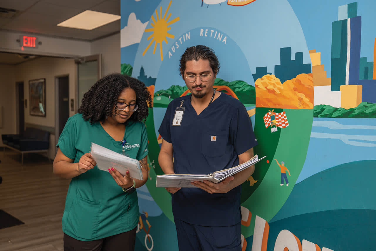 Clinical team members Braelyn Mouton and Brian Perez reviewing training materials before starting clinic.