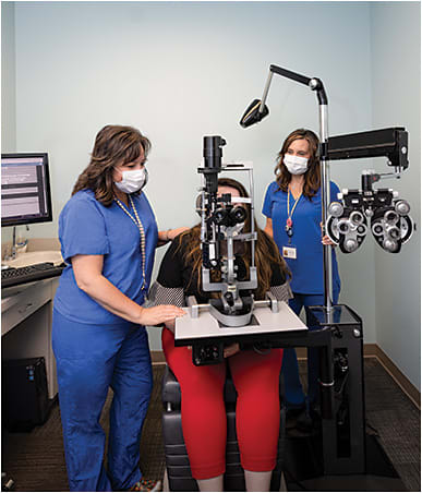 Technicians Dennise Boyce (left) and Stephanie Rich (right) assist a new patient.