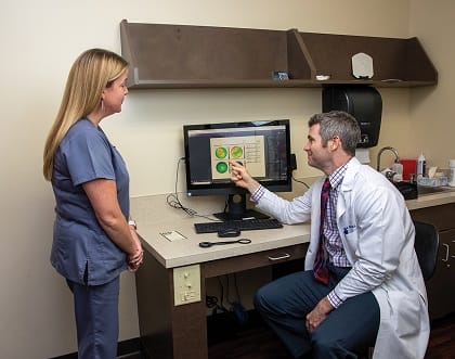 Patrick Redmond, MD, discusses topography results with Shannon Harris, COA, clinical manager.