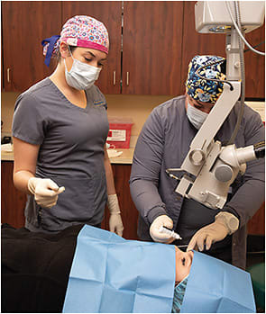Ophthalmic assistant Sarah Fuqua (left) observes Tammy Hutchinson, ophthalmic assistant (right), as she demonstrates how to instill drops.