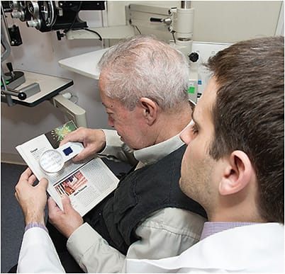 An optometrist teaches a low vision patient how to use a magnifier, so the patient can get the most out of its use.Photo courtesy of Lighthouse Guild