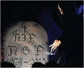Figure 3. The author play-acting the Grim Reaper at the grave of rigid contact lenses, presented at a contact lens conference in the Netherlands in 2010.