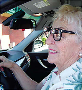 A low vision patient drives with her device assistance.