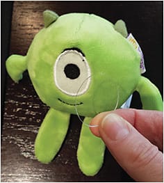 Figure 3. Fitting Mike Wazowski with a &#8220;contact lens&#8221; made from a demo lens helps Dr. Williamson acclimate young patients to the concept of contact lens wear.