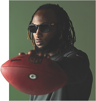 In this issue, EB checks in with NFL star Aaron Jones to learn about his unique on-field vision needs &amp;#x2B; his visionary alliance with Oakley. Here, Jones wears Oakley&amp;#x2019;s NFL Collection Green Bay Packers Holbrook. &amp;#xD;&amp;#xA;Photo: Courtesy of Oakley