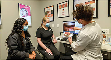 Susan Watson, MD, provides training for Sheena Thomas, CPO, ophthalmic technician (left), and Christa Sorlin-Davis, COA, ophthalmic technician (center).