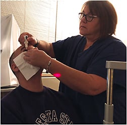 Pam Lightfield, laser technician and research coordinator, administers drops to a patient.COURTESY OF INDER PAUL SINGH, MD