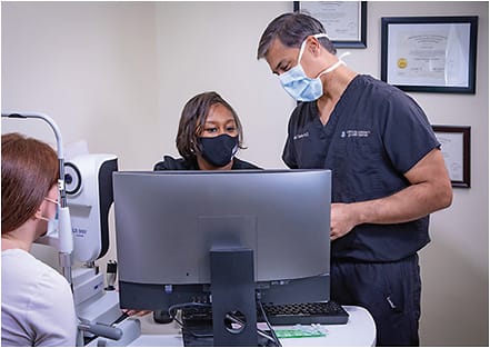 Dr. Budev discusses biometry findings with the patient, assisted by Ms. Pope.