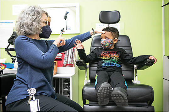 Mary DeYoung-Smith, CO, COMT, orthoptist, uses a finger puppet to capture the child’s attention.