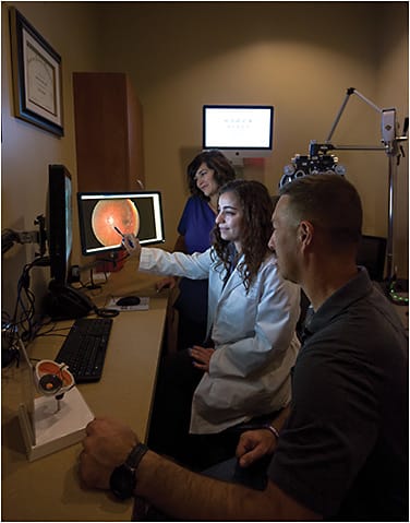 Sara Ghobraiel, MD (center), reviews fundus images with Tiffany Price, COA (left), and a patient.