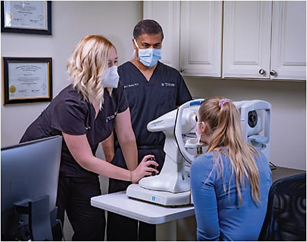 Millin C. Budev, MD, observes as Sarah Monson, COA, adjusts the corneal topographer.