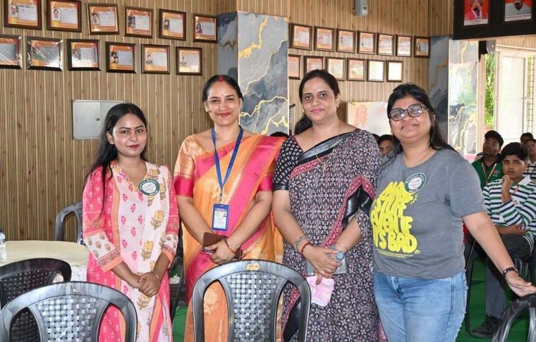 Four alumnae of Sunbeam School Ballia standing together in the hall during the meet, wearing the event’s badges.
