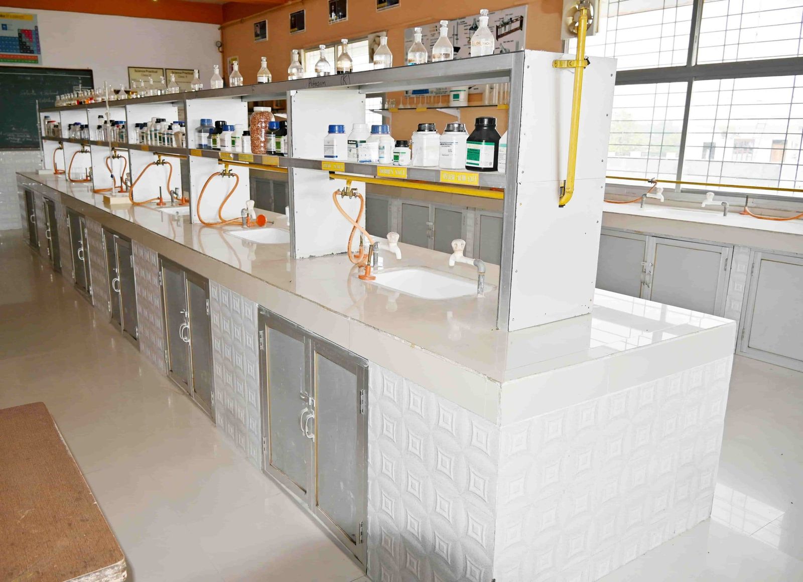 The chemistry laboratory at Sunbeam School Ballia, benches laid out with reagent shelves and gas taps.