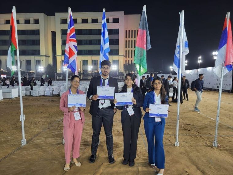 Sunbeam School Ballia students with the school flag at the IMUN summit in Indore — photograph 3 of 4