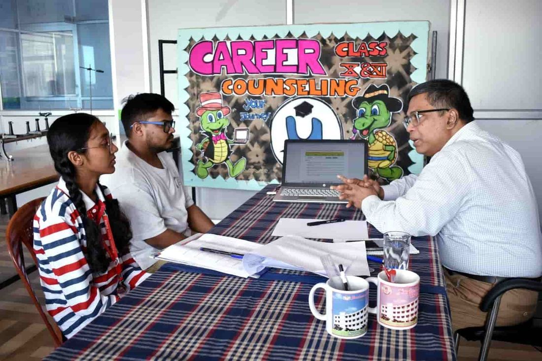 A student of Sunbeam School Ballia and a family member seated opposite a counsellor working from a laptop, the school's Class X and XI career counselling banner behind them