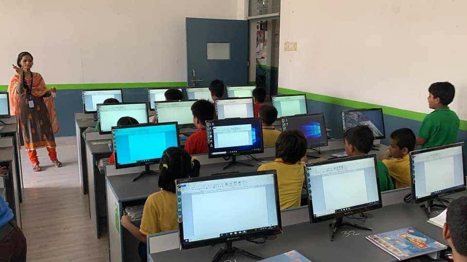 Younger students of Sunbeam School Ballia working at desktop computers in the junior computer laboratory