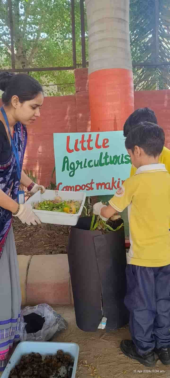 A young student of Sunbeam School Ballia adding kitchen scraps to the compost bin at the Little Agriculturists activity