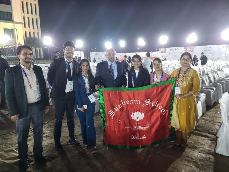 Sunbeam School Ballia students with the school flag at the IMUN summit in Indore — photograph 1 of 4