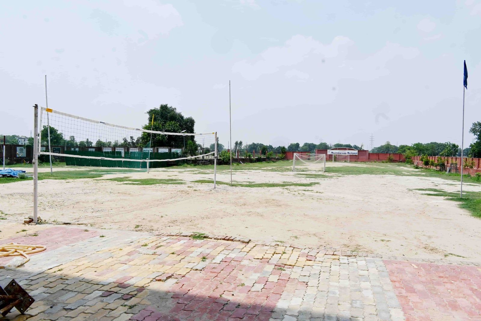 The JOSH ground at Sunbeam School Ballia, the volleyball court marked out and the school's name on the boundary wall