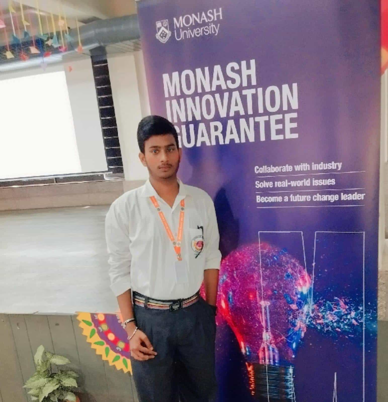 A student of Sunbeam School Ballia beside the Monash University Innovation Guarantee banner at an outreach session