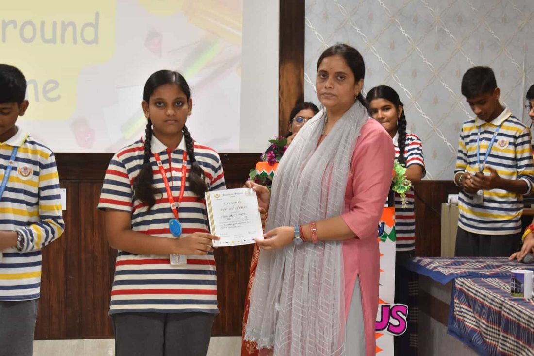 A student of Sunbeam School Ballia receiving a Citation of Appreciation from a teacher at the Impetus session