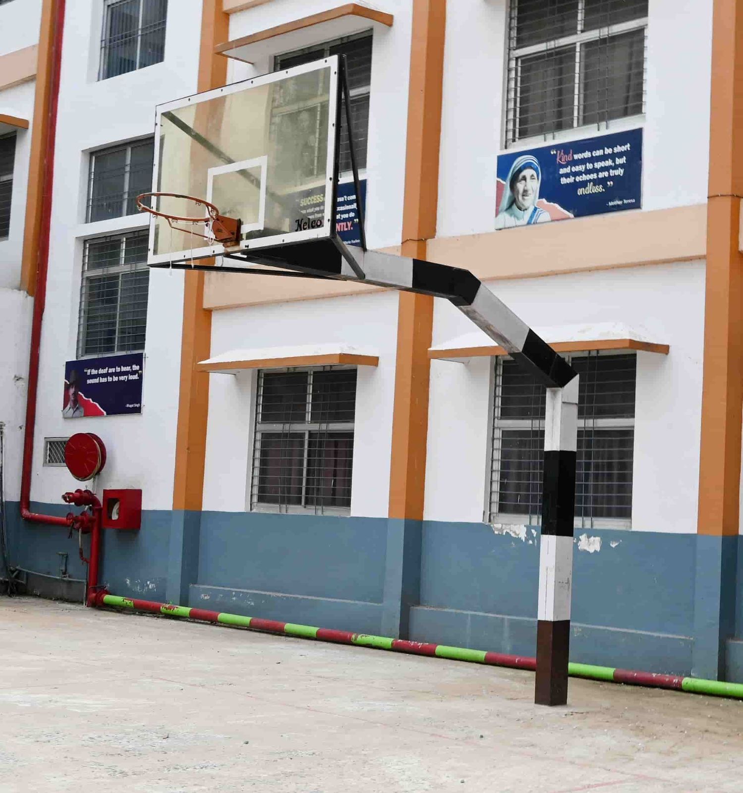 The basketball court at Sunbeam School Ballia, the hoop set against the school block