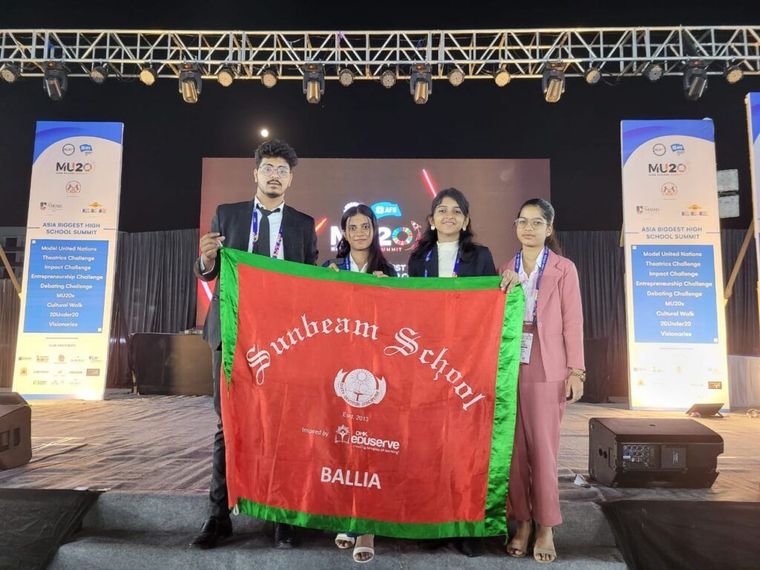 Sunbeam School Ballia students with the school flag at the IMUN summit in Indore — photograph 2 of 4