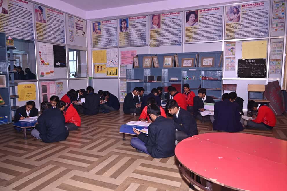 Students of Sunbeam School Ballia seated on the floor of a decorated activity room during a lesson