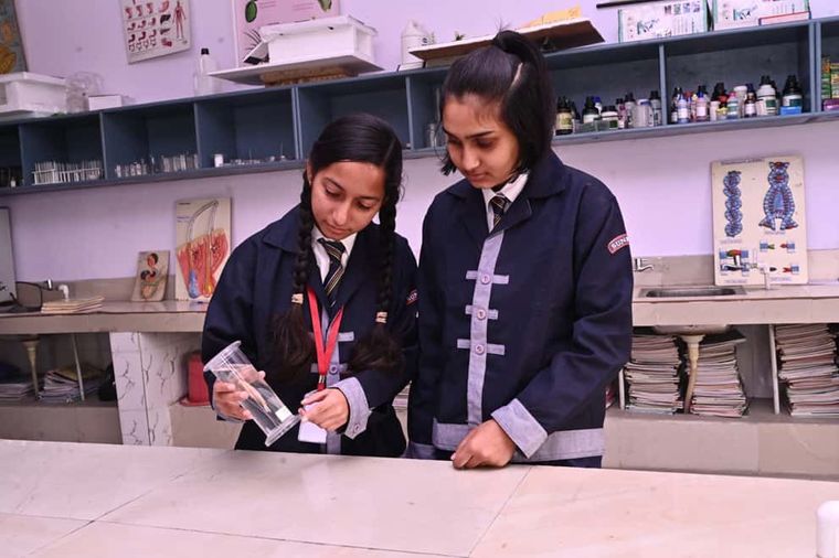 Two students of Sunbeam School Ballia handling glassware in the biology laboratory.