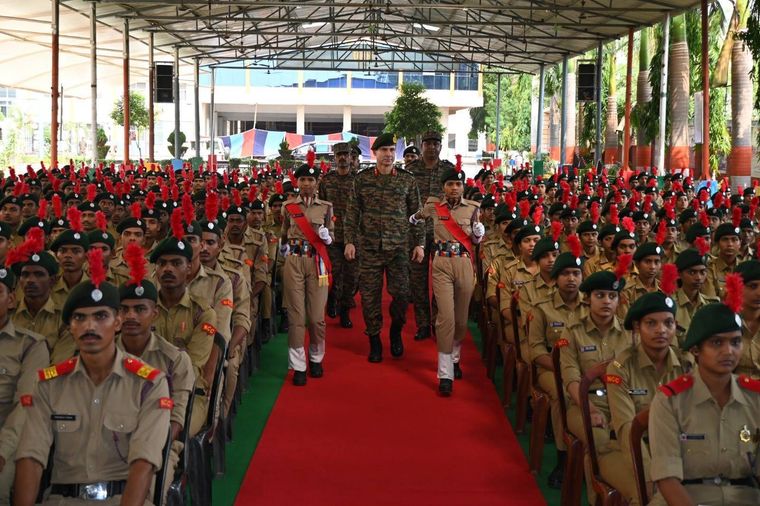Ranks of NCC cadets of Sunbeam School Ballia standing at attention beneath the assembly canopy while officers walk the red carpet between them.