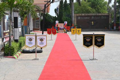 The entrance to Sunbeam School Ballia before Pradiptam 2.0 — a red carpet laid between house pennants, under the Alumni Meet 2026 board.