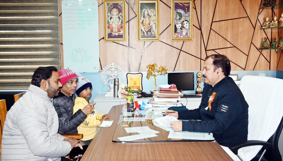 Two parents and a small child seated opposite a member of staff at Sunbeam School Ballia, admission forms across the desk