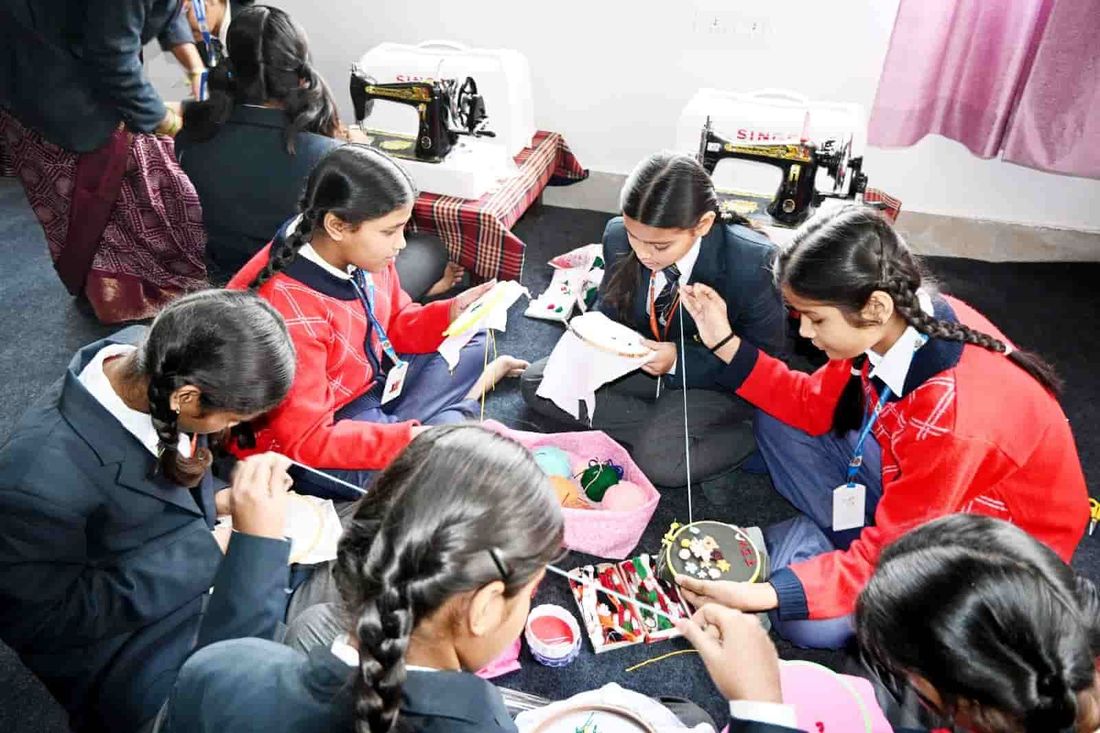 Students of Sunbeam School Ballia working on embroidery together from one shared basket of thread
