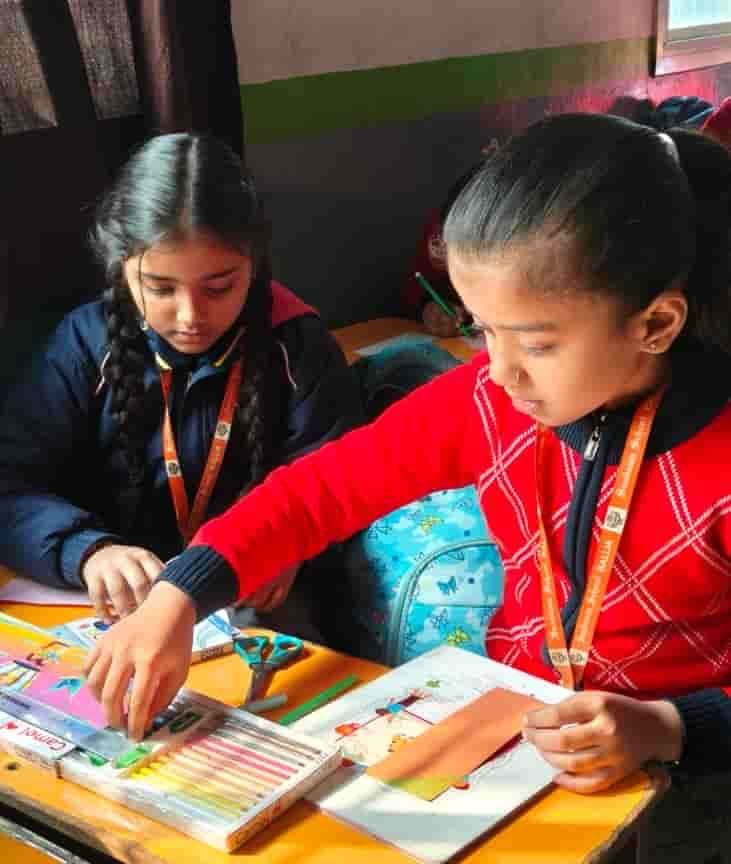 Two students of Sunbeam School Ballia sharing a desk, each working on her own drawing