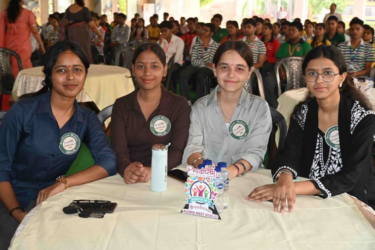 Four alumnae of Sunbeam School Ballia at a table, each wearing an Alumni Meet 2026 badge, a Pradiptam 2.0 card standing between them.