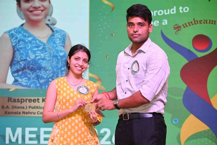 An alumna of Sunbeam School Ballia receiving her medallion, her honours degree in political science and her college named on the screen behind.